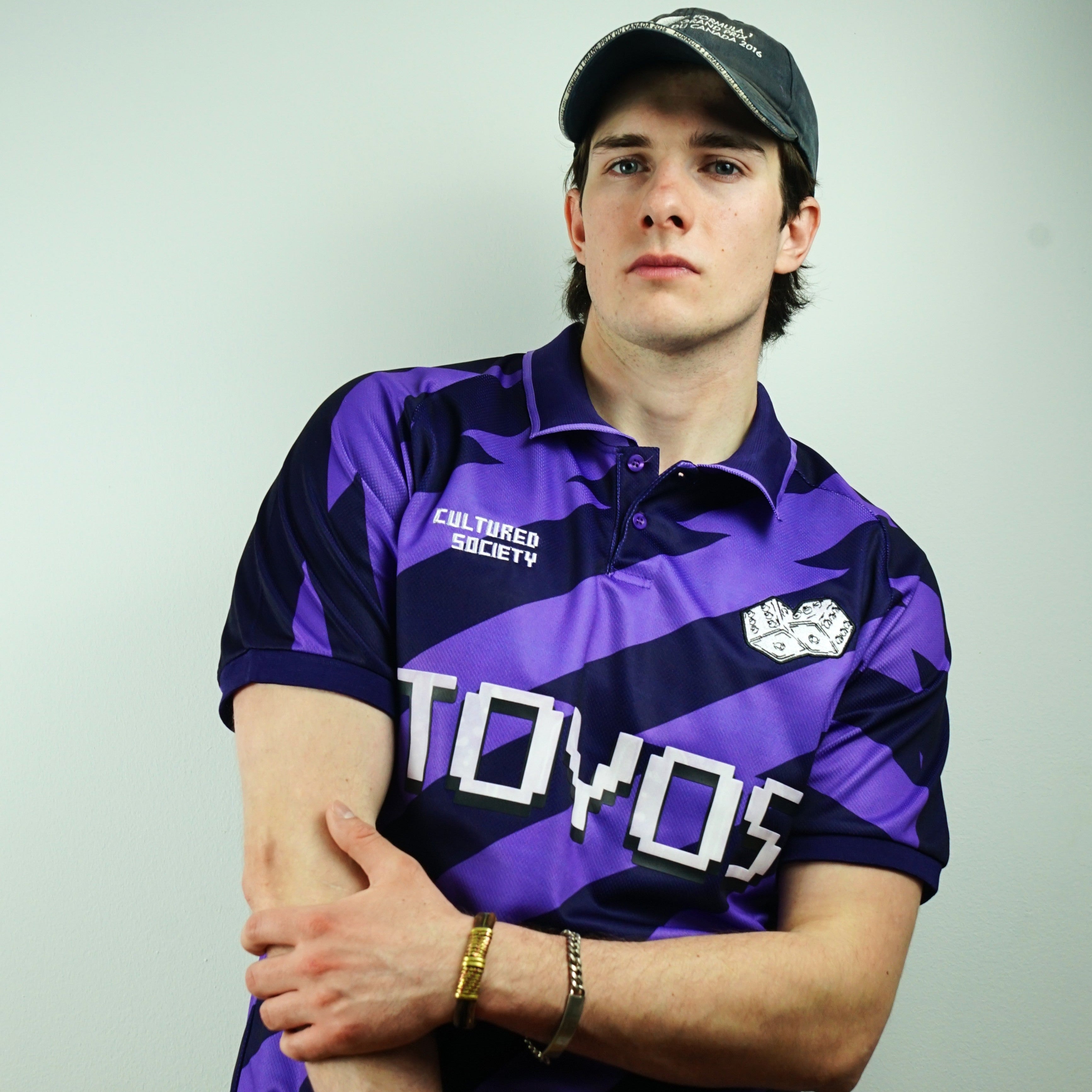 Person wearing a purple and black sports jersey with 'TOYOS' branding on a plain background