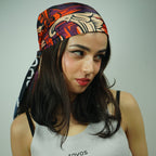 Woman wearing a colorful headscarf and a white tank top with 'TOYOS' branding.